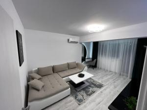 - un salon avec un canapé et une table dans l'établissement Amelia Apartment, à Braşov