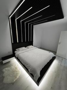 - une chambre avec un grand lit et une tête de lit noire dans l'établissement Amelia Apartment, à Braşov