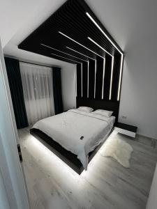 - une chambre avec un grand lit et une tête de lit noire dans l'établissement Amelia Apartment, à Braşov