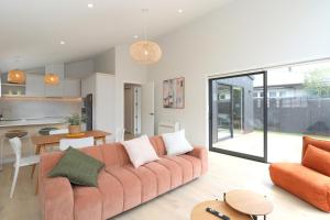 a living room with a couch and a kitchen at Urban Cube in Invercargill