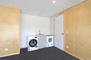 a laundry room with a washing machine and a door at Urban Cube in Invercargill