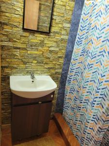 uma casa de banho com um lavatório e uma parede em mosaico em Cabaña tongarikii em Hanga Roa