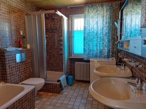 a bathroom with two sinks and a toilet and a shower at Ferienwohnung Grünwald in Grünwald +12 photos