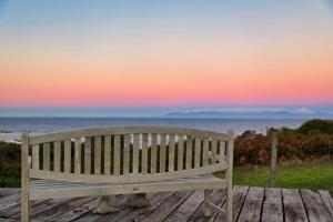 a wooden bench sitting on top of a wooden table at Bear Gully Coastal Cottages in Walkerville