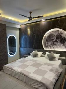 a bedroom with a large bed and a moon mural at Grand DLF Stays in Lucknow