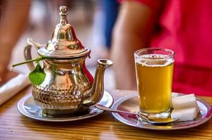 a tea kettle and a glass of beer on a table at Riad Dar El Hana in Taroudant