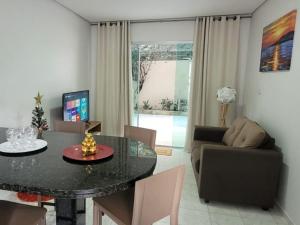 ein Wohnzimmer mit einem Tisch und einem Sofa in der Unterkunft Flat Aconchego das Meninas in Porto De Galinhas