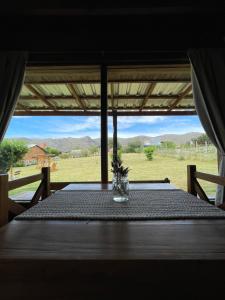 a table with a glass vase on top of it at Complejo El Yanten in Villa Ventana