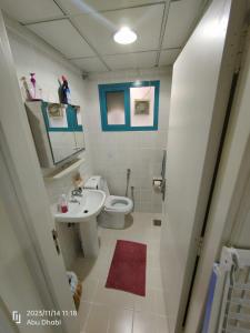 La salle de bains est pourvue d'un lavabo, de toilettes et d'un miroir. dans l'établissement Bedroom 3, Couples should be married, à Abu Dhabi