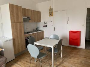 een keuken met een tafel en stoelen in een kamer bij Escapade dans le Golfe du Morbihan - T2 3ème étage in Auray