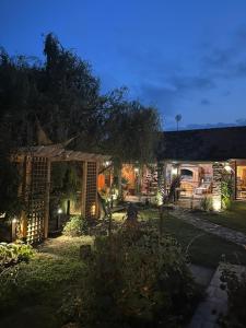 una casa con jardín por la noche con luces en San en Bijeljina