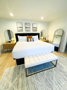 a bedroom with a large white bed and a bench at New Haven Inn in Solvang