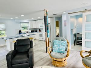 a living room with two chairs and a kitchen at Beachfront Bungalow in Clearwater Beach +37 photos