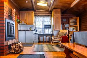 una cocina con armarios de madera y una mesa en una habitación en Aamun Kajo en Kuusamo