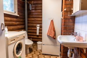 a bathroom with a washing machine and a sink at Aamun Kajo in Kuusamo