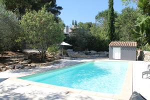 einen Pool im Hinterhof mit Bäumen und Felsen in der Unterkunft LES GITES DE VALERIE Appartement de 50m2 avec parking privé in Nîmes