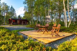 een houten terras met een tafel en stoelen erop bij Aamun Kajo in Kuusamo