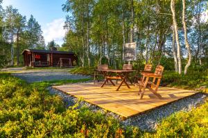 Una terraza de madera con una mesa y sillas. en Aamun Kajo, en Kuusamo