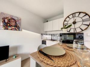 uma cozinha com uma mesa com um relógio na parede em EKLUSE - Renové - Proche Europapark Rulantica em Erstein