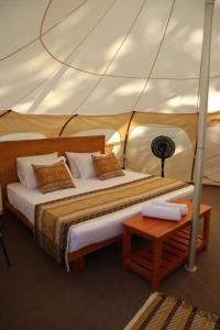 a bed in a tent with a table at Cabañas Tequendama Playa Arrecifes Parque Tayrona in El Zaino