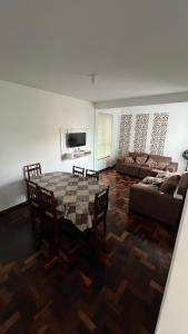 uma sala de estar com uma mesa e um sofá em Ap Central c/ Garagem em Ponta Grossa