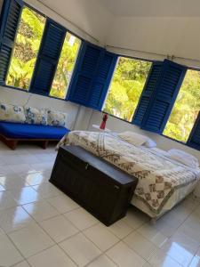 a bedroom with a bed with blue shuttered windows at Complejo Villa Clara Junto al Río y Montañas by drvacationsrental in La Laguna
