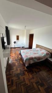 a bedroom with a bed and a flat screen tv at Ap Central c/ Garagem in Ponta Grossa