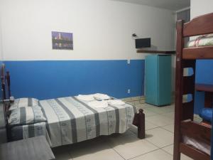 a bedroom with a bed with a blue headboard at Pousada Taiwan in Ubatuba