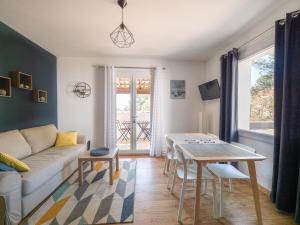 ein Wohnzimmer mit einem Sofa und einem Tisch in der Unterkunft LES GITES DE VALERIE Appartement de 50m2 avec parking privé in Nîmes
