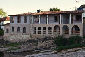 an old house on the side of a river at Serra Grisante Pousada Bed and Breakfast in Lençóis