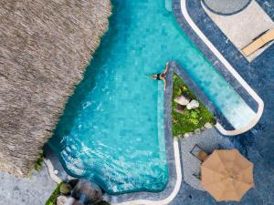 an overhead view of a swimming pool with an umbrella at Arenal Manoa Resort & Hot Springs in Fortuna