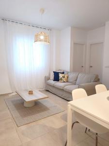 a living room with a couch and a table at SHERRY SUÍTES III Apartamentos PARKING GRATUITO in Jerez de la Frontera