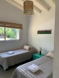 1 Schlafzimmer mit 2 Betten und einem Fenster in der Unterkunft Casa Aguaribay para 4 personas, cerca del centro, Merlo San Luis in Merlo