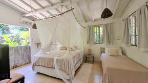 1 dormitorio con 1 cama con mosquitera en Vila Pitanga Trancoso, en Trancoso