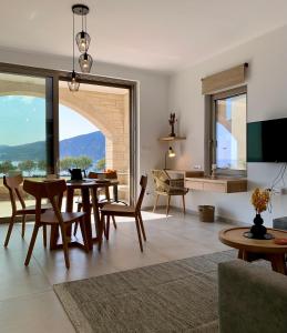 sala de estar con mesa, sillas y TV en Christos Place-Paleochora, en Palaiochóra