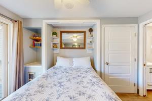 a small bedroom with a bed and a mirror at Misty Harbor Beach Retreat in Gilford