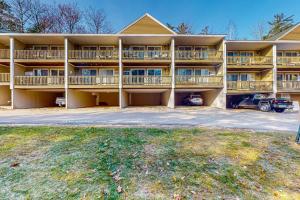 a large apartment building with balconies and a parking lot at Misty Harbor Beach Retreat in Gilford