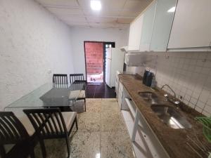 uma cozinha com um lavatório, uma mesa e cadeiras em Casa Cmc011 Simples e Objetiva Com Estacionamento em Brasília