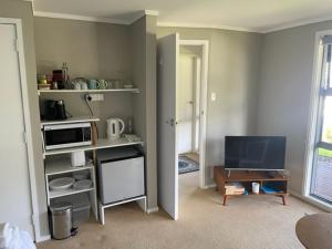 a room with a living room with a television at The Pacific Room, Tapeka Point in Russell