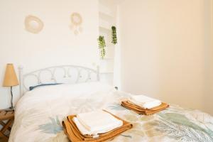 1 dormitorio con 1 cama con toallas en Le Cocon d'Alesia ~ T3 Cosy Proche Ligne 4 Paris, en París