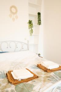 1 dormitorio con 1 cama con toallas en Le Cocon d'Alesia ~ T3 Cosy Proche Ligne 4 Paris, en París