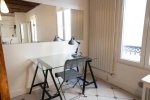 escritorio con lámpara y silla en una habitación en Le Cocon d'Alesia ~ T3 Cosy Proche Ligne 4 Paris, en París