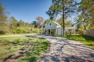 uma casa com uma entrada de cascalho em frente em Pet-Friendly Conroe Hideaway with Porch and Fire Pit em The Woodlands