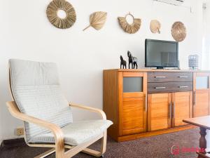 uma sala de estar com uma cadeira e uma televisão em Brisas del Mar Mediterráneo em Oropesa del Mar