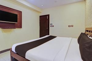 a bedroom with a bed and a flat screen tv at Flagship Grand Sandarshini Inn Near MGBS Bus station in Hyderabad