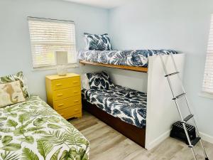 a bedroom with two bunk beds and a desk at Beachfront Bungalow in Clearwater Beach
