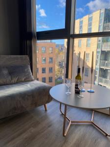 a living room with a bed and a table with wine glasses at Deluxe City Centre Studio Apartment with Balcony & City Views - FREE WIFI NETFLIX, GYM ACCESS - WESTONE in Sheffield