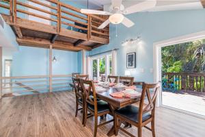 een eetkamer met een tafel en stoelen en een plafondventilator bij Palm Paradise - Pet Friendly Home on Siesta Key w/ Large Heated Private Pool & Outdoor Area! in Sarasota