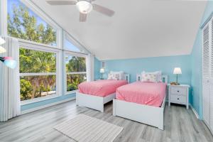 twee bedden in een kamer met twee ramen bij Palm Paradise - Pet Friendly Home on Siesta Key w/ Large Heated Private Pool & Outdoor Area! in Sarasota +56 foto's