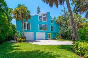 een blauw huis met palmbomen ervoor bij Palm Paradise - Pet Friendly Home on Siesta Key w/ Large Heated Private Pool & Outdoor Area! in Sarasota